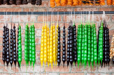 travel to Georgia - multi-colored Kakhetian churchela (traditional Georgian candle-shaped candy from grape must, nuts and flour) in village store in Kakheti region of Georgia clipart