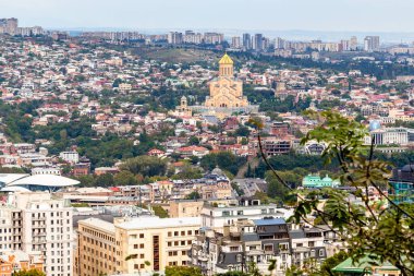 travel to Georgia - above view of Tbilisi city with Holy Trinity Cathedral from Mount Mtatsminda on autumn day clipart