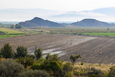 Sonbahar sabahı Ermenistan 'ın Ararat ovasında tarım arazileri ve tarlaları ekildi. Arka planda dağlarda sis vardı.