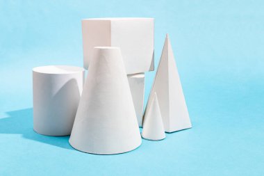 kopyalanmış mavi arkaplan üzerinde farklı el yapımı kağıt geometrik nesneler