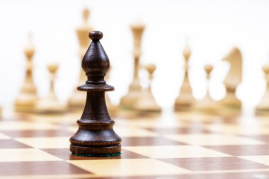 Siyah fil arka planda beyaz satranç figürlerine karşı ahşap satranç tahtasında yakın plan (vezire odaklan)