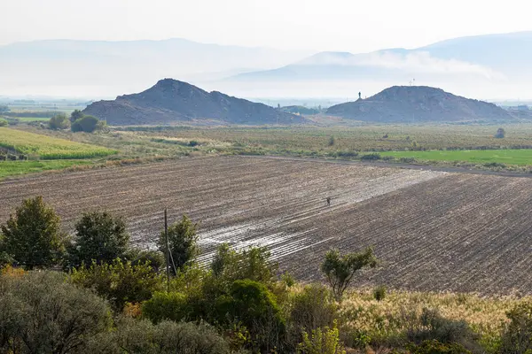 Sonbahar sabahı Ermenistan 'ın Ararat ovasında tarım arazileri ve tarlaları ekildi. Arka planda dağlarda sis vardı.