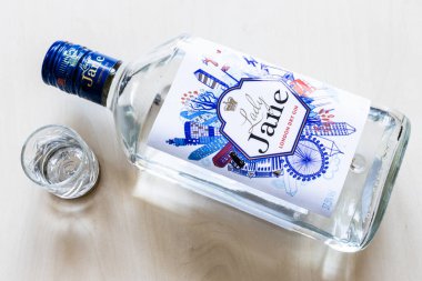 Moskova, Rusya - 1 Ekim 2024: Açık kahverengi tahta üzerinde içki şişesi ve yalan söyleyen Leydi Jane London Cin