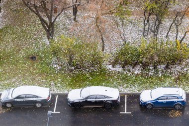 above view of car parking area near city park after first snow in residential district clipart