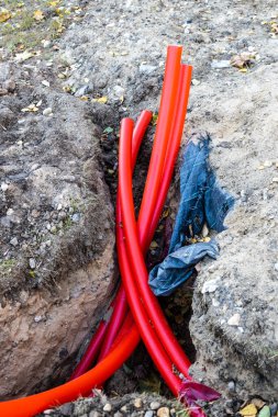 Dışarıdaki yeraltı elektrik kabloları için bir grup kırmızı plastik boru.