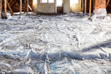 Tavan arası polietilen film ve yenilendikten sonra genişletilmiş kil kalıntılarıyla kaplı.