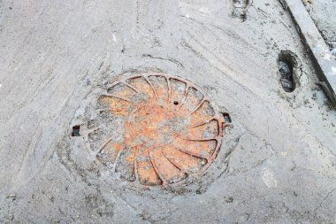 Paslı demir şehir kanalizasyon rögar kapağı yağmurlu bir günde yetersiz beton yol ve insan ayak izleri
