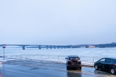 Kostroma şehrindeki donmuş nehrin yanındaki otoparkta mavi kış akşamı alacakaranlığında.