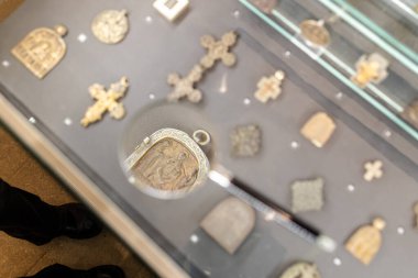 Moskova, Rusya - 13 Mart 2025: Kurtarıcı Andronikov Manastırı 'ndaki Antik Rus Kültür ve Sanat Müzesi' nde haç ve muskalarla sergi standında büyüteç