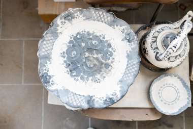 Gzhel, Rusya - 21 Mart 2025: Rusya 'nın Moskova Bölgesi' ndeki Gzhel Porselen Fabrikası 'nın atölyesinde ateşlenmemiş tabakların en üst görüntüsü