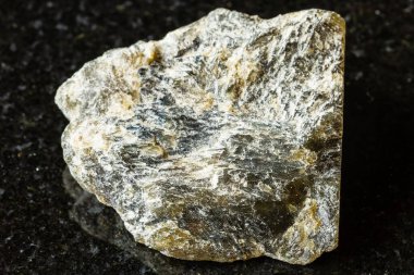 Madagaskar yakınlarında siyah granit zemin üzerinde koyu yeşil labradorit minerali örneği