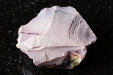 Avustralya 'dan yakın plan siyah granit üzerine çiğ mor mookait minerali örneği