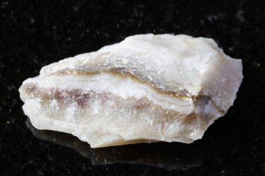 Shaitanka, Orta Ural, Rusya yakınlarındaki siyah granit arka planda cilalanmamış şeytan perelivte minerali örneği.