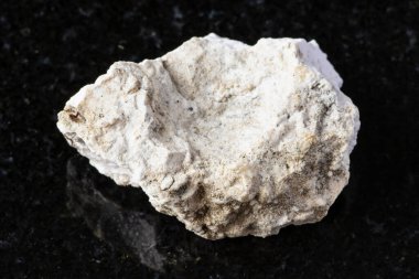 Rusya 'nın Kola Yarımadası yakınlarındaki siyah granit zemin üzerinde ham albit taşı örneği