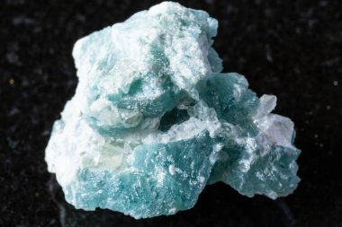 Siyah granit arka planda ham brüt mineral örneği. Orta Urallar, Rusya 'dan yakın plan.