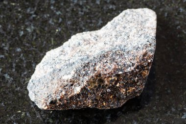 Rusya 'nın Kola Yarımadası yakınlarındaki siyah granit arka planda ham phlogopit minerali örneği