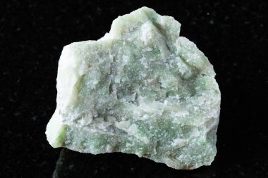 Siyah granit arka planda ham rodingite minerali örneği. Kazakistan 'dan yakın plan.