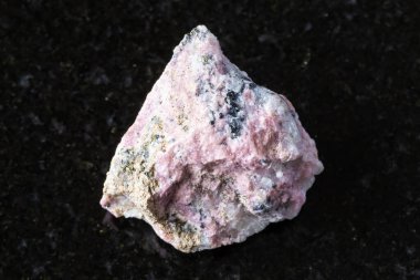 Colorado, ABD 'den kapatılan siyah granit arka planda ham pyroxmangite minerali örneği