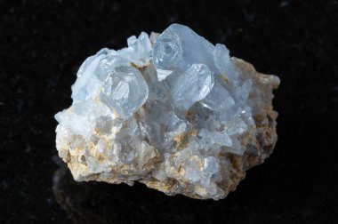 Siyah granit arka planda kaba Celestine minerali örneği yakın plan