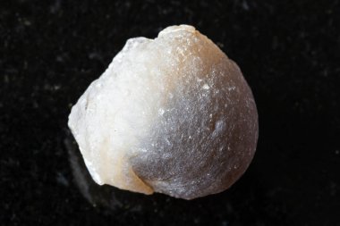 Siyah granit arka planda kesilmemiş agat minerali örneği yakın plan