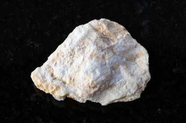 Siyah granit arka planda ham xonotlite minerali örneği. Azerbaycan 'a yakın.