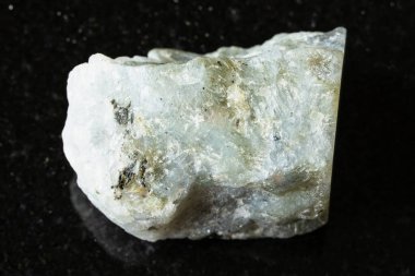 Madagaskar yakınlarındaki siyah granit arka planda ham gri labradorit minerali örneği