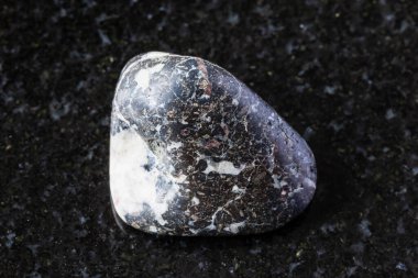 Siyah granit zemin üzerinde cilalanmış trachybazalt kaya örneği Rusya, Kutup Uralları 'ndan yakın plan