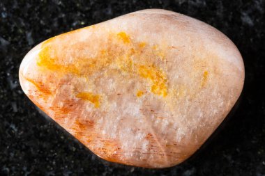 Madagaskar 'a yakın siyah granit arka planda parlak feldspat minerali örneği