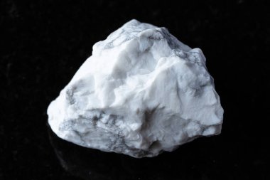 Siyah granit arka planda ham howlite minerali örneği yakın plan