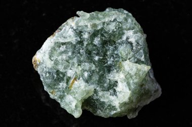 Kesilmemiş yeşil bulvar taşı örneği siyah granit arka planda yakın plan