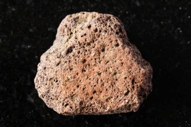 Siyah granit arka planda ham kahverengi sünger minerali örneği yakın plan