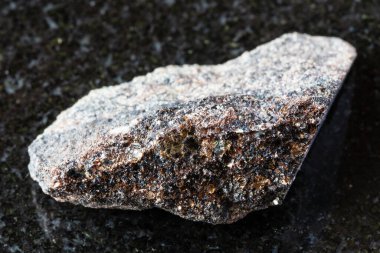 Rusya 'nın Kola Yarımadası yakınlarındaki siyah granit arka planda ham phlogopit mika örneği