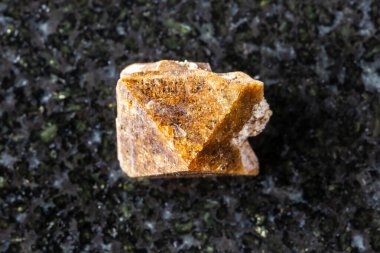 Khibiny, Kola Yarımadası, Rusya yakınlarındaki siyah granit zemin üzerinde tek bir zirkon kristali örneği