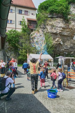 Palyaço, Almanya 'nın Haigerloch kentindeki Kültür Günleri' nde çocuklar için sabun köpükleri yapıyor.