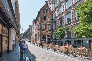 Brüksel 'in merkezinde ünlü bir bar olan Poechenellekelder binasında renkli bisikletler ve duvarlarında çerçeveli resimler.