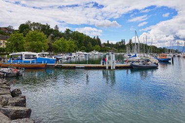 Sailboats are anchored along the pier at the port on Lake Geneva. Bad weather and heavy clouds caused yachts to leave the marina