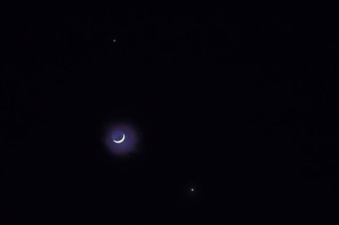 Parlayan ay ve yanında iki yıldız Gecenin karanlığında gökyüzünde