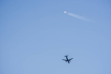 İki farklı uçak tatil için mavi gökyüzüne doğru farklı yönlere uçuyor.