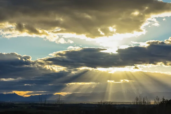 Świecące Słońce Między Chmurami Podczas Zachodu Słońca Krajobrazie Górami — Zdjęcie stockowe