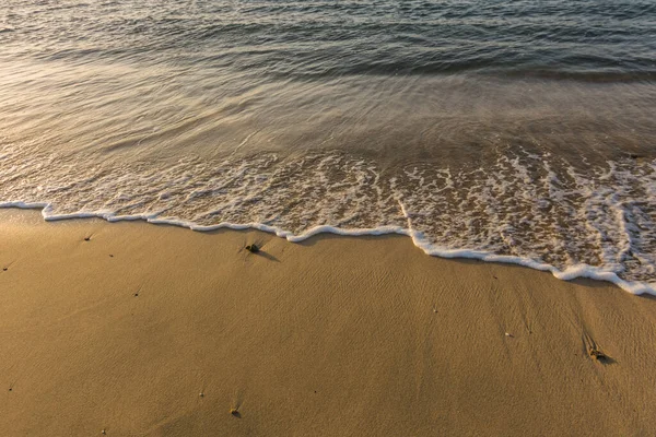 在埃及海滩上的细沙上飘扬着白沫的波浪 — 图库照片