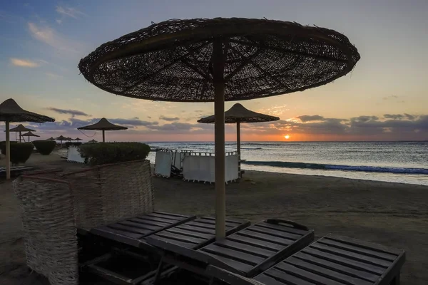 在假日的早上看日出的时候 在海滩上的雨伞和日光浴床 — 图库照片