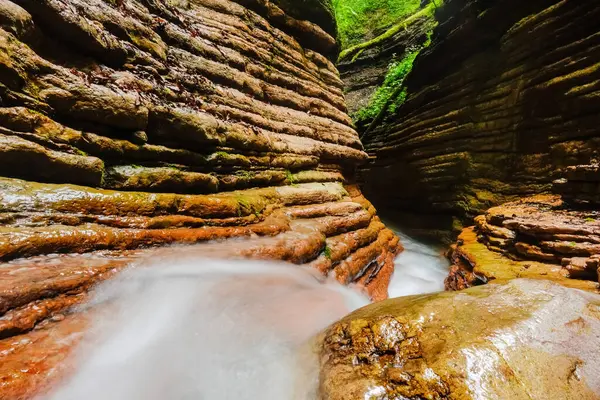 İnanılmaz kırmızı kanyon arasında kayaların katmanları ve hızlı akan soğuk akıntılar var.