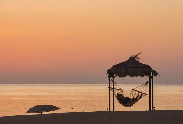 couple in a hammock at the beach waiting for the sunrise on vacation
