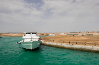 Tekneli iskele ghalib, Mısır 'da yeşil deniz suyu ve çöl.