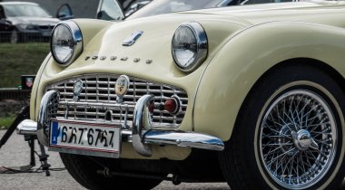 Yazın bir araba fuarı sırasında açık yeşil klasik bir arabanın önünde.