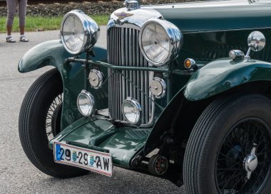 Yazın bir araba fuarı sırasında çok eski, klasik bir arabanın önünde.