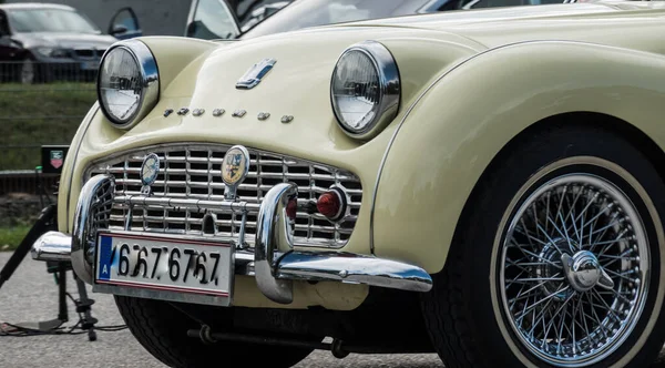 Yazın bir araba fuarı sırasında açık yeşil klasik bir arabanın önünde.