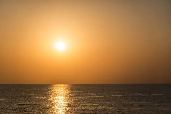 very bright white sun with reflection in the water during sunrise in egypt
