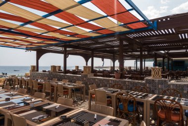 Sahildeki restoranın kumaştan yapılmış renkli bir çatısı ve Mısır 'da deniz manzarası var.