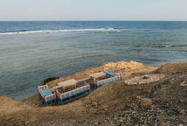 Mısır 'da tatilde kumsalda ve denizde masaları ve bankları olan rahat bir yere bakın.